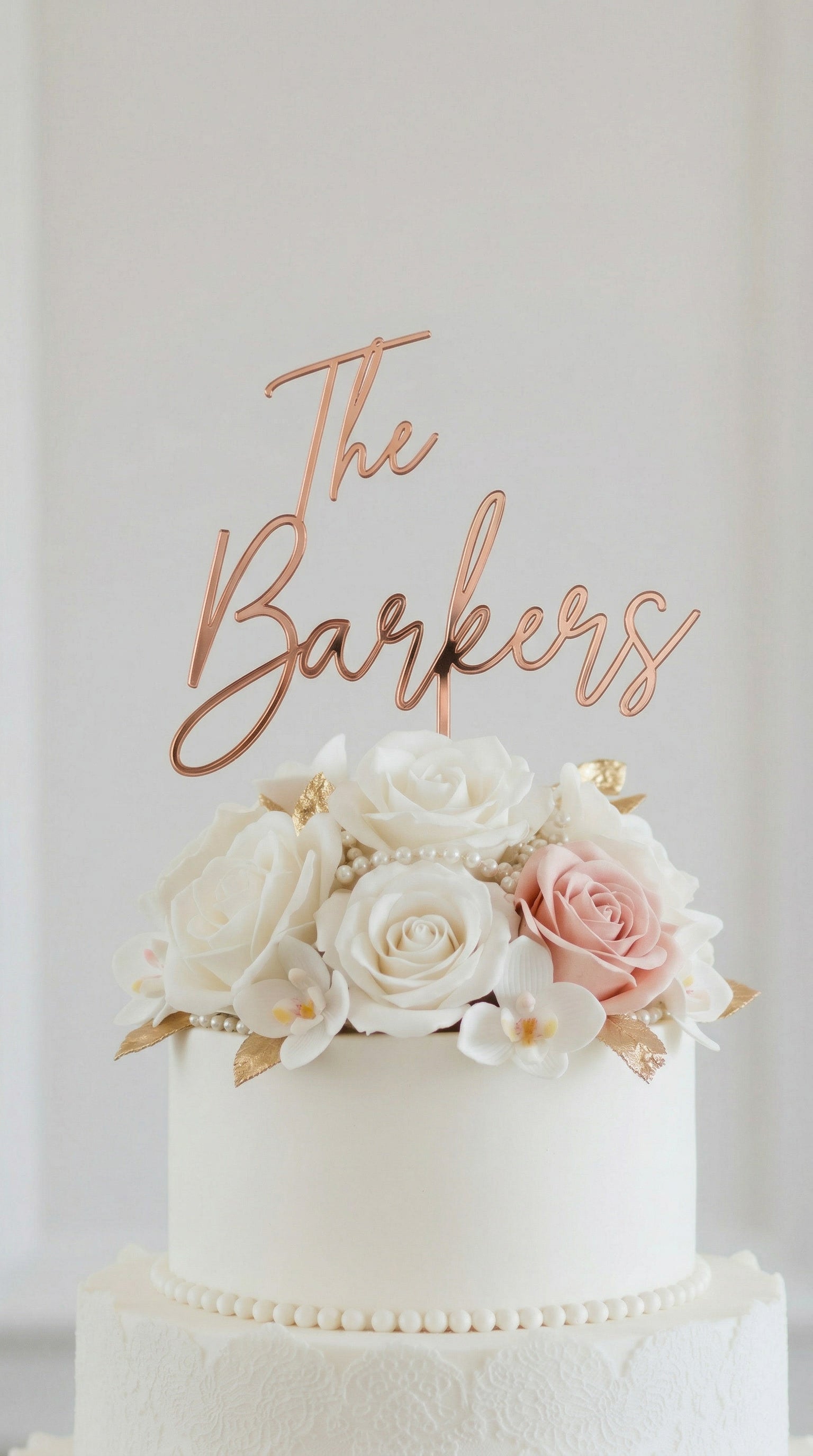 Wedding cake toppers personalized acrylic name sign on white wedding cake with floral decorations and soft background